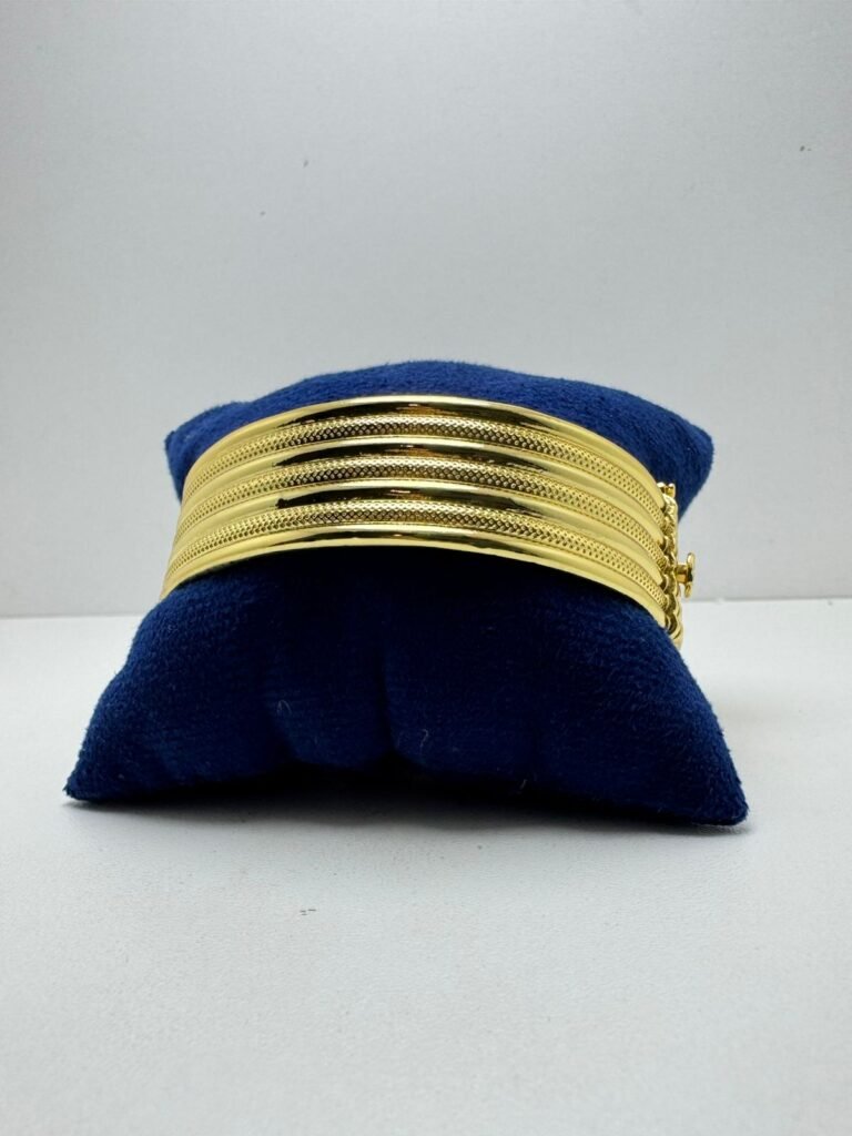 a gold bracelet on a blue pillow