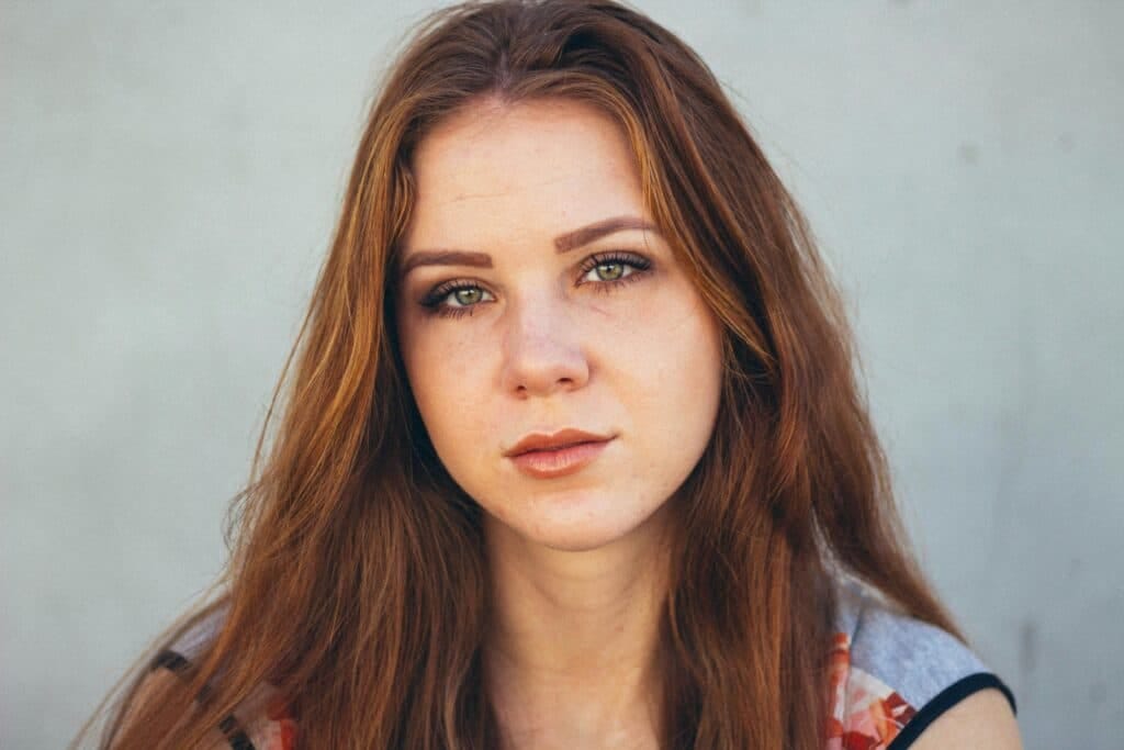 pexels-photo-2169434-2169434 Stunning close-up portrait of a young woman with red hair and expressive eyes.